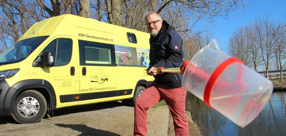 Harald Gülzow nimmt eine Wasserprobe