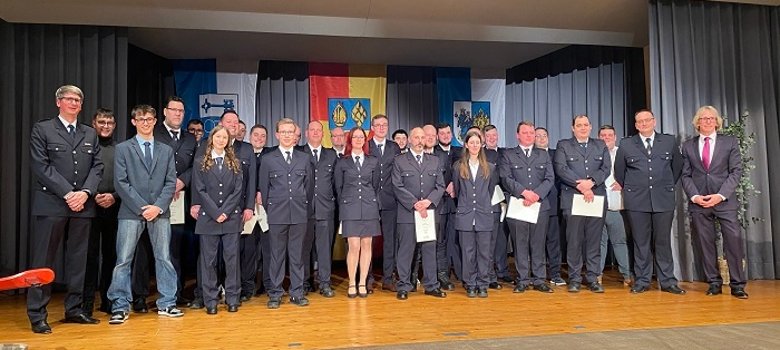 Auf der Bühne: Im Rahmen des Kameradschaftsabends nahm Bürgermeister Stefan Veth folgende Verpflichtungen, Beförderungen und Ernen­nungen von Feuerwehrangehörigen vor